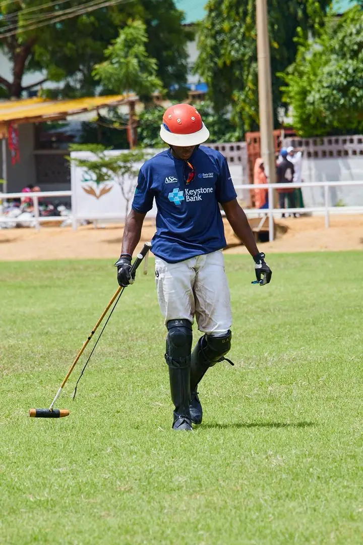 Keystone team player walking off the pitch carrying his polo mallet