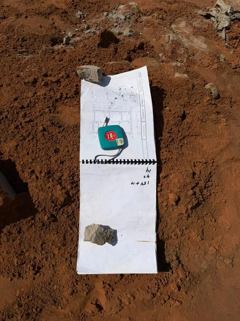 Site layout drawing and tape measure laid out on cleared red earth during an AS5 Group site assessment
